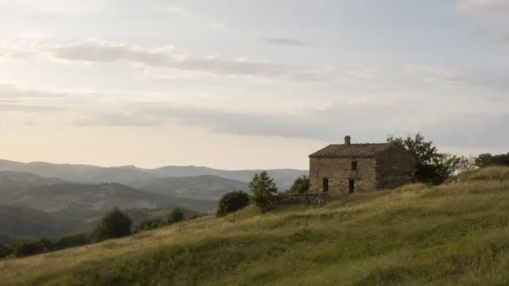 Paesaggio collinare con casolare in pietra, sanatoria paesaggistica